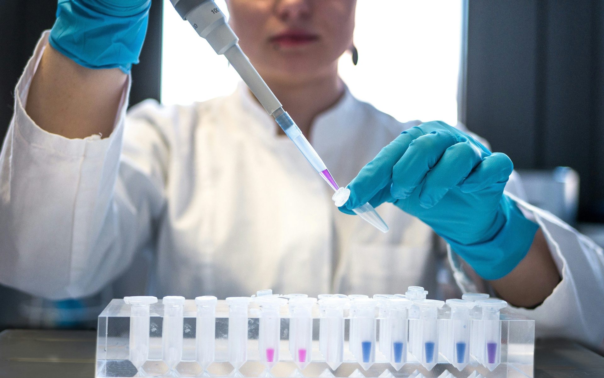 scientist using pipette with test tubes in lab